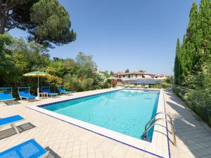 una piscina con sedie e ombrelloni in un cortile di Villa La Rosa by Interhome a Montelupo Fiorentino