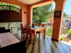 a room with a table and chairs on a balcony at Il Bacio di Roma in Infernetto