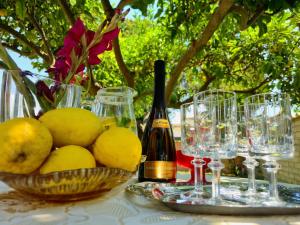 a table with glasses and a bowl of lemons and a bottle of wine at Il Bacio di Roma in Infernetto +17 photos