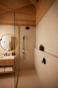 a bathroom with a shower and a sink and a mirror at Natures Channel at Dimensions - Cabin Twelve in Algonquin Highlands