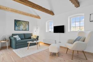 a living room with a blue couch and two chairs at 5533-Hvide-Sande-Sonder-Klitvej-84-3 in Havrvig