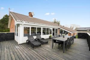 Una terraza de madera con una mesa y sillas. en 354-Hvide-Sande-Fyrmarken-24, en Hvide Sande