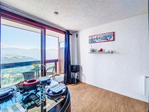 una stanza con un tavolo e una grande finestra di Studio Pegase Phenix-66 by Interhome a Le Corbier Altre 26 foto