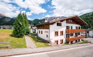 a house in the mountains with a yard at Apartments Lores in Selva di Val Gardena