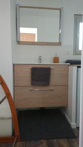 y baño con tocador de madera y espejo. en Dojo avec gîte tout confort dans nature ardéchoise, en Tournon-sur-Rhône