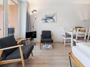 a living room with a bed and a table and chairs at Apartment Promenade Apt 109 & Apt 110 by Interhome in Arosa +35 photos