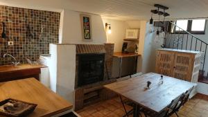 una sala de estar con una mesa y una chimenea en Dojo avec gîte tout confort dans nature ardéchoise, en Tournon-sur-Rhône