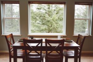 a dining room table with chairs and two windows at Lakeshore Lodging Apartment H in Homer +3 photos