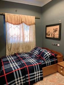 a bedroom with a bed and a window at StayCommidad in Tamale