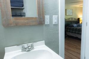 a bathroom with a sink and a mirror and a bed at Near Lake Texoma Quad-plex Kitchenette - 27 in Mead