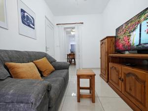 a living room with a couch and a flat screen tv at Valletta CityVibes in Il-Furjana