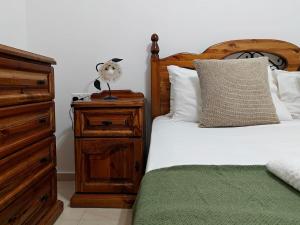 a bedroom with two beds and a nightstand with a bed sidx sidx at Valletta CityVibes in Il-Furjana