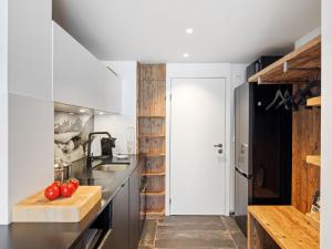 Una cocina con gabinetes blancos y una encimera con tomates en una tabla de cortar. en Apartment Promenade - Utoring-93 by Interhome, en Arosa