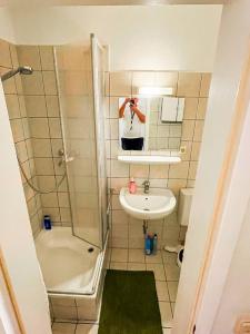 a man taking a picture of a bathroom with a sink and shower at Zentrale 1 Zimmer Wohnung mit Küche in Frankfurt/Main