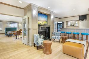 a lobby with a fireplace and a dining room at Clarion Pointe Sioux Falls Airport in Sioux Falls
