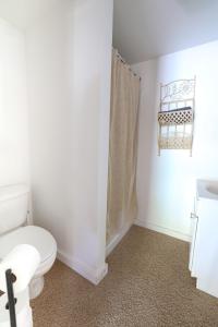 un bagno bianco con wc e doccia di Wilderness West Resort Cabin 2 a Colville