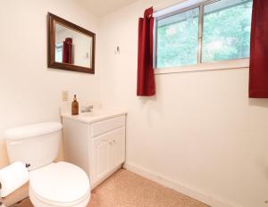 een witte badkamer met een toilet en een raam bij Wilderness West Resort Cabin 1 in Colville +22 foto's