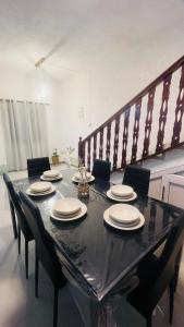 a black table with chairs and plates on it at Zilwest Villa in Flic-en-Flac
