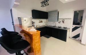 a kitchen with black cabinets and a black chair at Zilwest Villa in Flic-en-Flac