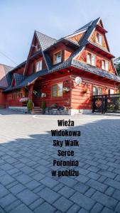 a wooden house with a sign in front of it at Gościniec U Ani - pod wieżą widokową Sky Walk, nieopodal szlaków na Polane Rusinową , Gęsią Szyje, Polane Zgorzelisko , Tarasówke i Palenice in Male Ciche