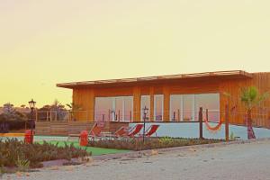 a building with a swimming pool with chairs in front of it at Herdade da Yucca - Retreat & Spa in Terena