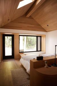 a bedroom with a large bed and two windows at Wildflower Rest at Dimensions - Cabin Fifteen in Algonquin Highlands