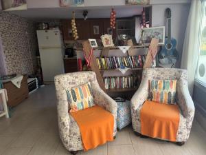 two chairs with orange cushions in a living room at Seda Otel Çeşme in Çeşme