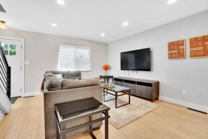 a living room with a couch and a flat screen tv at Twin Abodes Two Units One Group Getaway in Arvada