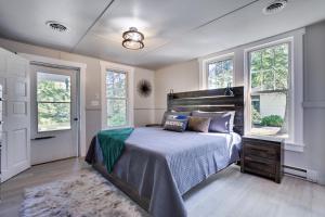 a bedroom with a bed and two windows at Heatherbell, A Lakeside Retreat in Saylorsburg