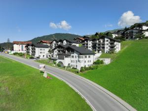 a road in a village with houses on a hill at Apartment La Siala Apt-19 by Interhome in Falera