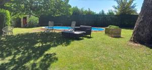 Le Mélomane - Maison climatisée avec jardin clos في Montfrin: ساحة مع طاولة وكراسي ومسبح