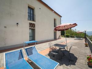 a patio with a table and an umbrella and a pool at Apartment Antico Loggiato-3 by Interhome in Pontassieve