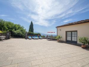 a patio with chairs and umbrellas in front of a building at Apartment Antico Loggiato-2 by Interhome in Pontassieve
