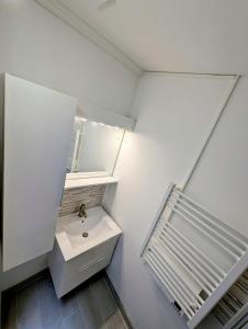 a white bathroom with a sink and a mirror at 2 bedroom house Bourbourg in Bourbourg