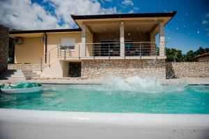 a swimming pool in front of a house at Villa Ruška in Ljubuški