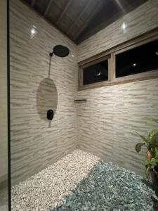 a corner of a room with a stone wall at Umaloka Eco Villa in Tirtagangga +17 photos