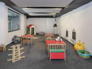 ein Zimmer mit Tischen und Stühlen sowie einem Spielbereich in der Unterkunft Apartment La Siala Apt-30 by Interhome in Falera