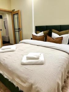 two towels are sitting on top of a large bed at Camera Dogarilor in Sibiu