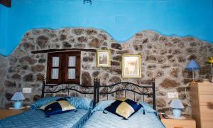 una camera da letto con un letto con un muro di pietra di La Ermita a Loroñe