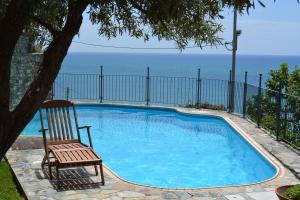 アレンツァーノにあるCa da Muntà bed and breakfastの海を望むスイミングプールの隣に椅子