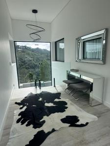 a living room with a desk and a large window at CASA MAGNÍFICA EM CAMPOS DO JORDÃO - Nova in Campos do Jordão
