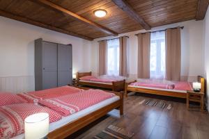 Tres camas en una habitación con techos y ventanas de madera. en Chata Homola - Telgárt Resort, en Telgárt