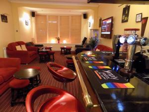 Un bar con taburetes rojos y una barra con barra. en The Norwood, en Blackpool