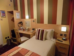Un dormitorio con una cama y un escritorio con una computadora. en The Norwood, en Blackpool
