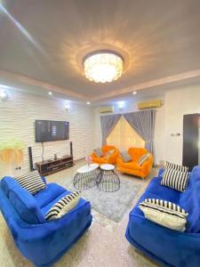 a living room with blue couches and a flat screen tv at Chevy in Lekki
