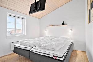 a bedroom with two beds and a tv on the wall at 362-Hvide-Sande-Fyrmarken-35 in Hvide Sande