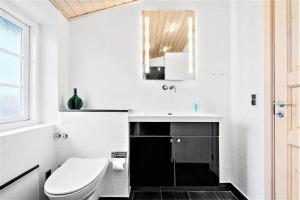 a white bathroom with a toilet and a sink at 362-Hvide-Sande-Fyrmarken-35 in Hvide Sande +32 photos