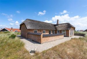 a brick house with a roof on a patio at 362-Hvide-Sande-Fyrmarken-35 in Hvide Sande