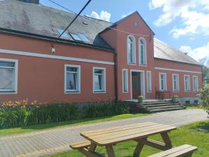 a picnic table in front of a red building at Agroturystyka Goliat in Zapolice