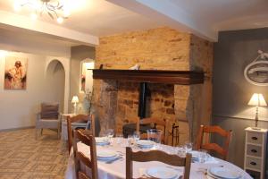 uma sala de jantar com uma mesa e uma lareira em gite de la ruelle des messes em LʼÉchelle